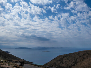 A steep and dangerous road down leading to Stara Baska Beach. Thick clouds above. Beautiful coastal line of Croatia. Beach is surrounded with tall hills from each side. Hidden gem of Croatia