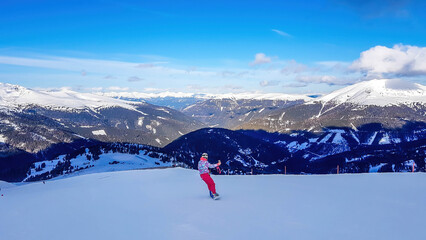 A snowboarder going down the slope in Turrach, Austria. Perfectly groomed slopes. High mountains...