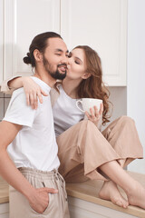 Couple in love having breakfast in the kitchen, multinationality