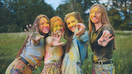 Fototapeta premium Cheerful girls posing smeared in multi-colored powder.