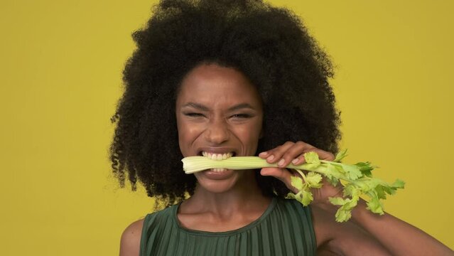 Beautiful woman biting into piece of celey
