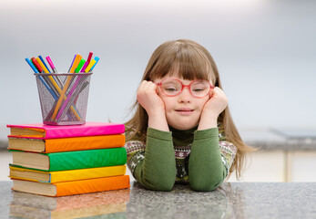 A girl with down syndrome is engaged in creative work at home in the kitchen. Accessibility of education for children