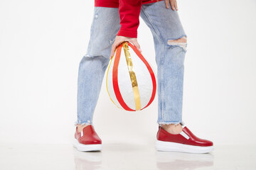 Red beautiful fashionable female loafers shoes on leg of girl or woman. Studio shoot on white...