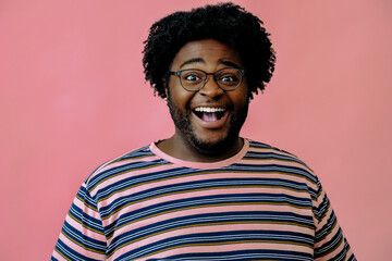 Obraz premium young happy african american man posing in the studio over pink background