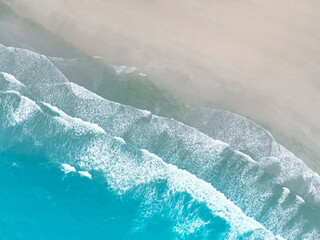 Aerial view by drone with waves crashing on the beach in Maldives