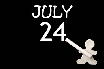 A small white plasticine man writing the date 24July on a black board. Business concept. Education concept.