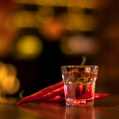 vodka shot with chilli pepper on wooden table square