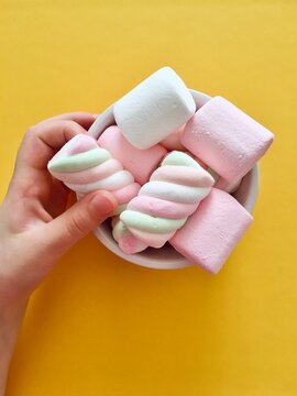 Overhead view of a child's hand reaching for a marshmallow