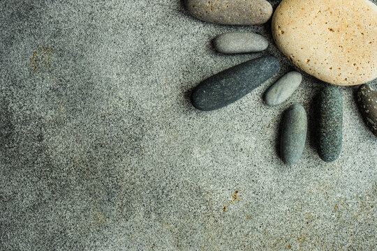 Overhead view of assorted pebbles on a table arranged in the shape of the sun
