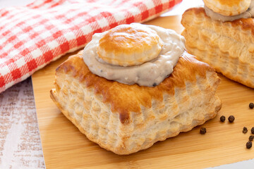 puff pastry garnished with veal rice on wooden board