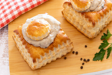 puff pastry garnished with veal rice on wooden board