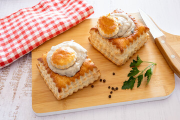 puff pastry garnished with veal rice on wooden board