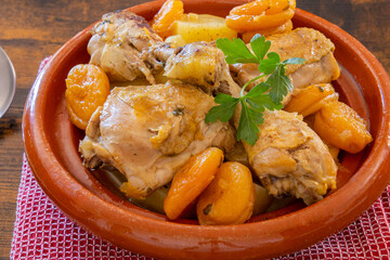 piece of chicken cooked with apricots in a dish