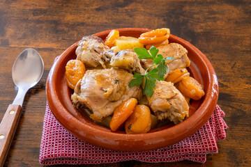 piece of chicken cooked with apricots in a dish