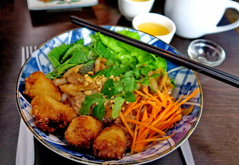 Bo bun dans un bol avec sauce et baguettes.