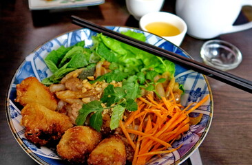 Bo bun dans un bol avec sauce et baguettes.
