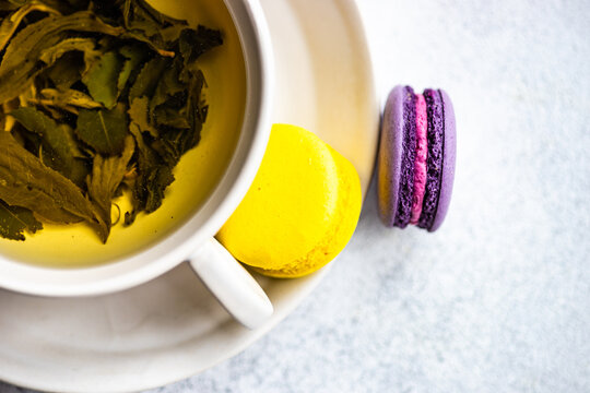 Cup of green Soursop tea with lemon and lavender macaroons