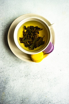 Cup of green Soursop tea with lemon and lavender macaroons