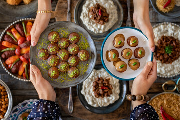 Family dinner with many foods on the table and dessert at the hands of two woman