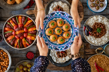 Family dinner with many foods on the table and dessert at the hands of two woman