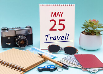Travel planning, vacation trip - Calendar with the date 25 May glasses notepad pen camera cash passports.