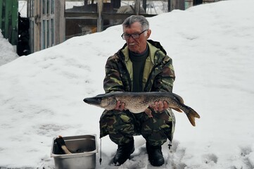 The fisherman demonstrates the caught river fish. Large predatory fish pike .