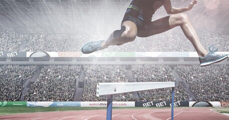 Naklejka premium Composite image of caucasian low section of male athlete jumping over hurdles against sports stadium