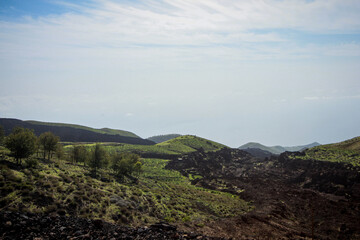 Fototapeta premium Volcanic ground on curvy road to Pico do Fogo, volcano on the island of Fogo on Cabo Verde islands. Looking towards the top of the mountain.