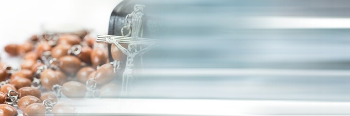 Blur effect with copy space against close up of a rosary and holy bible