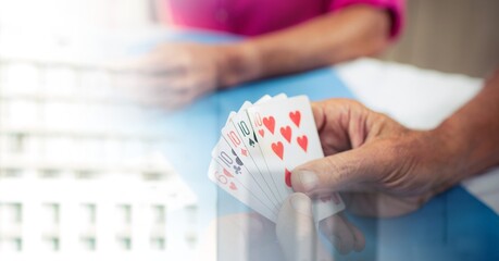 Blur effect with copy space against mid section of senior people playing cards