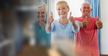 Blur effect with copy space against portrait of group of senior people showing thumbs up
