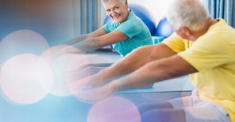 Blur effect with copy space against senior couple performing stretching exercise at retirement home