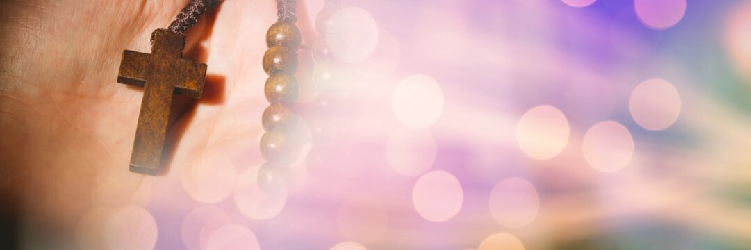Blur effect with copy space against close up of a hand holding a rosary