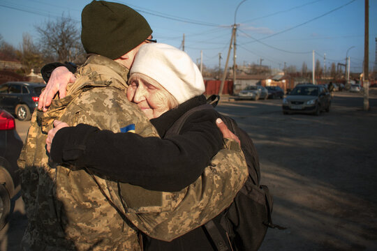Military son hugs an elderly mother goodbye. Mom hugs a Ukrainian soldier. militarization. The Ukrainian defender says goodbye to his family. Mobilization of Ukrainian men. War of Ukraine and Russia
