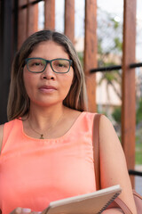 Hispanic business woman outdoors with glasses.