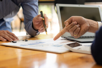 Two businessmen holding graph pens brainstorm new project business strategy plans and analytical factsheets. Business, Finance and Accounting Consultant Meeting