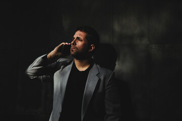 Low key of executive man talking angrily on mobile phone and looking to the left