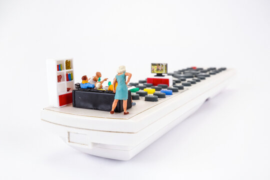 Family spending time together channel surfing and watching a television, conceptual photography. Miniature figurines on the TV remote, watching football match or movie.