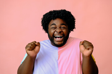 Fototapeta young happy african american man posing in the studio over pink background obraz