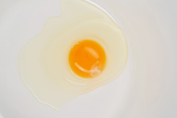 Yellow yolk and albumen in a white plate. Shallow depth of field
