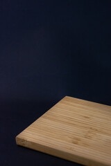 Empty wooden chopping board on dark background
