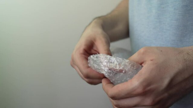 a man pops a bubble wrap. guy popping bubble wrap