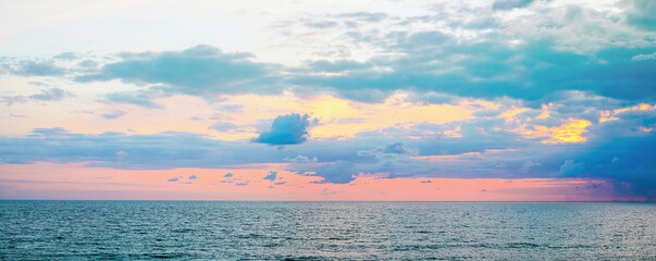 Beautiful colorful evening sunset sky over sea in blue and pink tones.