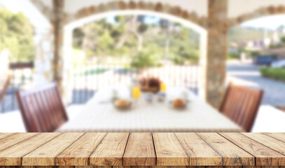 Empty wooden table with blurred luxury garden with swimming pool on background