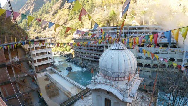 4K Wide angle shot of Gurudwara Sahib Manikaran from above with prayer flags surrounding the Gurudwara at Manikaran near Kasol in Himachal Pradesh, India. 