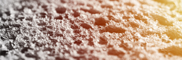 gray texture of white bread as close up background. textured surface slice of white loaf or toast of natural organic food with holes. toned in black white. top view. depth of field. banner. flare