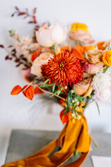 modern wedding bouquet in autumn style, with orang ranunculus  and Gerbera