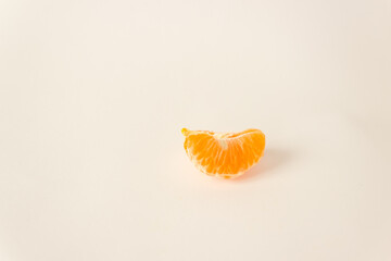 One orange peeled slice of mandarin citrus fruit isolated on white background. Looks like a smile. Healthy eating.