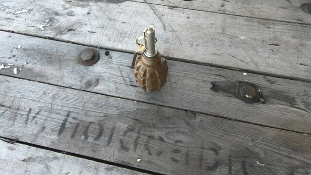 a hand grenade with a hand on a wooden table video without processing