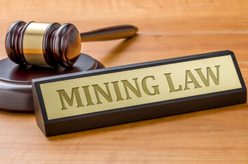 A gavel and a name plate with the engraving Mining law